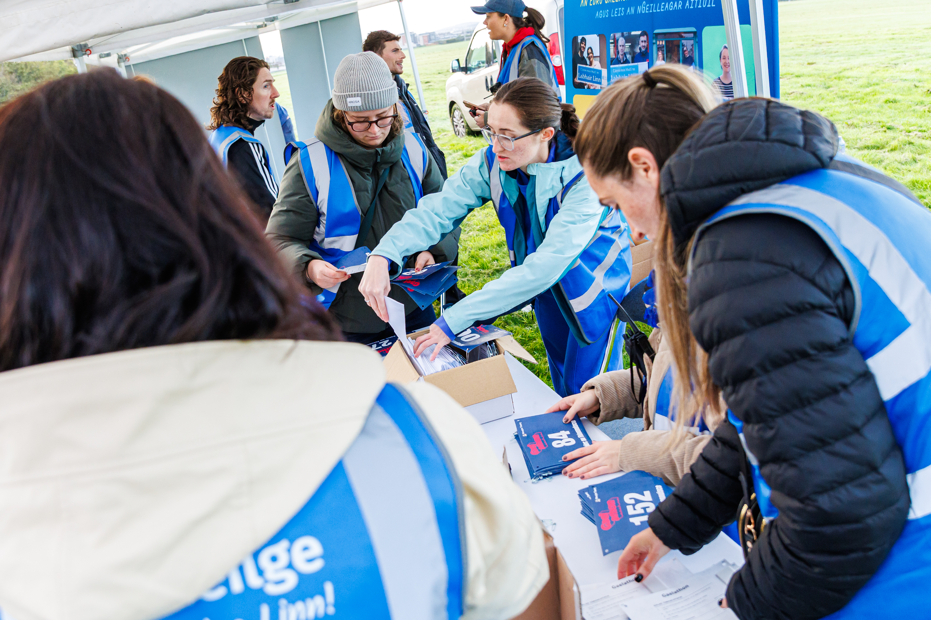 Volunteers distribute Gaelathon race bibs at the registration tent